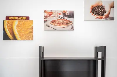 a table in front of a wall with three pictures at Caracciolo Apartment - Metro San Giovanni in Rome
