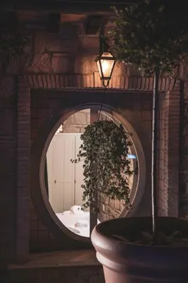 a round mirror with a potted plant and a light at Domus Luxury Gianicolo in Rome