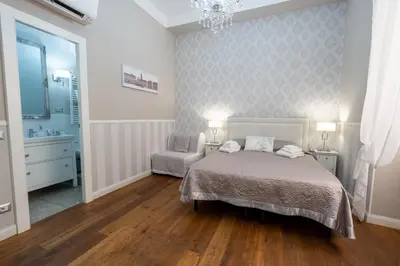 a bedroom with a bed and a chair at Casa De Rose in Rome