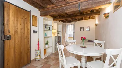 a kitchen and dining room with a white table and chairs at Rental in Rome Falegnami in Rome