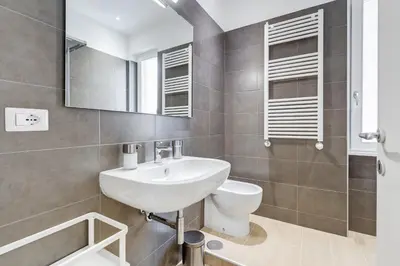 a bathroom with a sink and a mirror at Lovely 3 rooms apartment close Trastevere Station in Rome