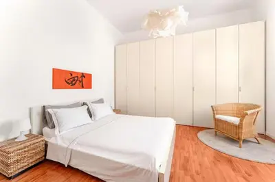 a bedroom with a large white bed and a chair at Casa della Salita San Pietro in Rome