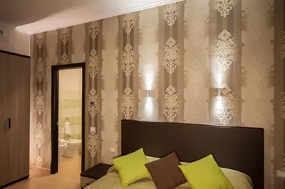 a bedroom with a bed and a wall with wallpaper at Rome Kings Suite in Rome