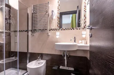 a bathroom with a sink and a toilet and a mirror at Rome Kings Suite in Rome