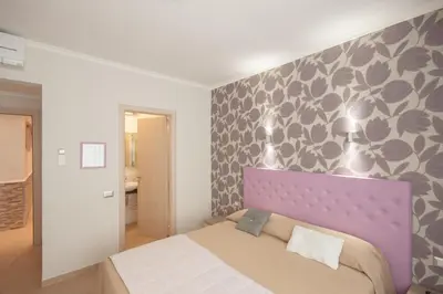 a bedroom with a bed with a purple headboard at Rome Kings Suite in Rome
