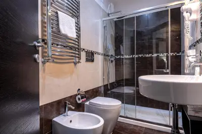 a bathroom with a toilet and a sink and a shower at Rome Kings Suite in Rome