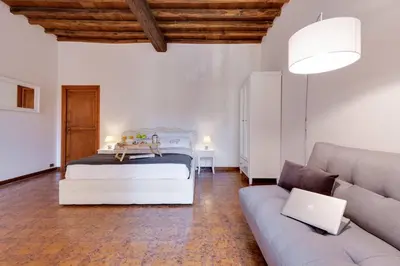 a bedroom with a bed and a couch and a laptop at Arenula Luxury Apartment in Rome
