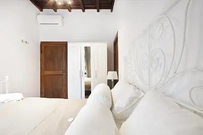 a bedroom with a large white bed with white pillows at Arenula Luxury Apartment in Rome