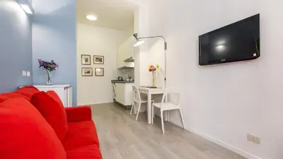 a living room with a red couch and a tv on a wall at Rental in Rome Beato Angelico in Rome