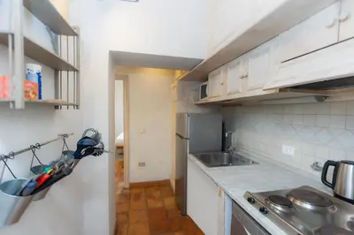 a kitchen with white cabinets and a stainless steel refrigerator at Rental in Rome Leonardo da Vinci in Rome