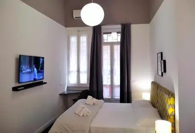 a hotel room with two beds and a tv at Casa Italiano - BestBnB Garbatella in Rome