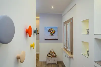 a hallway with white walls and a dog picture on the wall at Many Days Apartments in Rome
