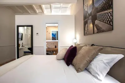 a bedroom with a bed with white sheets and pillows at Pantheon Suites Rome 2 in Rome