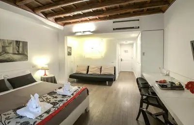 a bedroom with a bed and a desk in a room at Relais Fori Imperiali in Rome