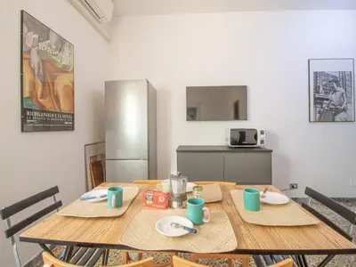 a wooden table with two chairs and a kitchen at Apartment Aurelia by Interhome in Rome