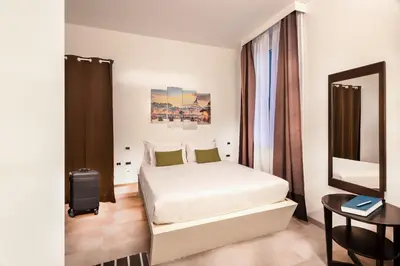 a bedroom with a white bed and a mirror at Navona Stay in Rome