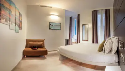 a bedroom with a white bed and a chair at Navona Stay in Rome