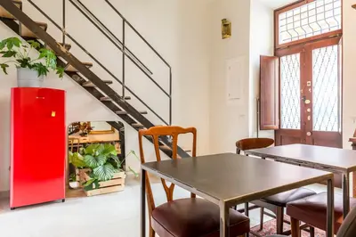 a room with a table and chairs and a red refrigerator at Torre Tolomei Trastevere in Rome