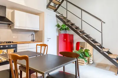 a kitchen with a table and chairs and a staircase at Torre Tolomei Trastevere in Rome