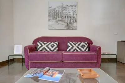 a purple couch in a living room with a coffee table at Colosseo Gardens - My Extra Home in Rome
