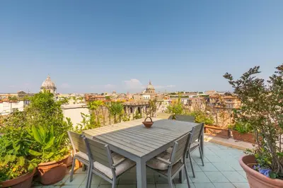 a table and chairs on a balcony with a view at Farnese Stunning Penthouse | Romeloft in Rome