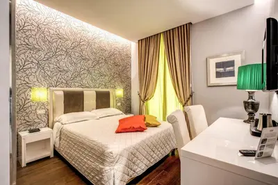 a bedroom with a bed and a desk with a computer at Boutique Rome Inn in Rome