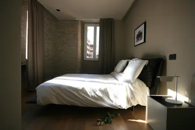 a bedroom with a bed with white sheets and a window at Campo Marzio Luxury Suites in Rome
