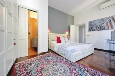 a bedroom with a white bed and a rug at LUXURY APARTMENT VATICANO-S'PETER BASILICA - NETFLIX Wifi - AirCond in Rome
