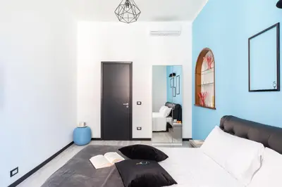 a bedroom with blue walls and a bed with pillows at A World Aparts - 32 Modena in Rome
