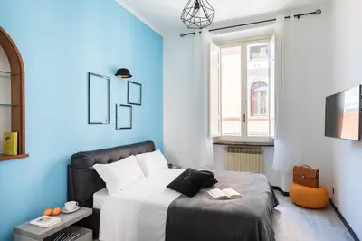 a blue bedroom with a bed and a window at A World Aparts - 32 Modena in Rome