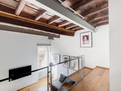 a living room with white walls and wooden ceilings at Loft in Trastevere in Rome