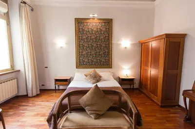 a bedroom with a bed and a large painting on the wall at Monia Coliseum Apartment in Rome