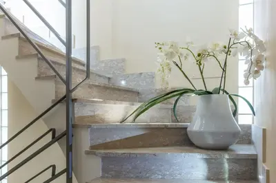 a vase with flowers sitting on a stair case at La camelia bianca in Rome