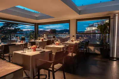 a restaurant with tables and chairs and large windows at Twentyone Hotel in Rome
