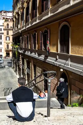 a couple of people sitting on the steps of a building at Domus Maya Colosseum in Rome