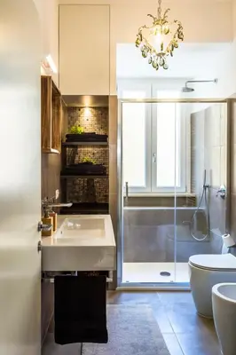 a bathroom with a sink and a toilet and a chandelier at Domus Maya Colosseum in Rome