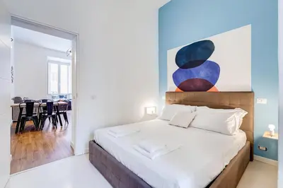 a bedroom with a bed with a painting on the wall at BMGA l Central Holiday House 2Bdr near Vatican in Rome