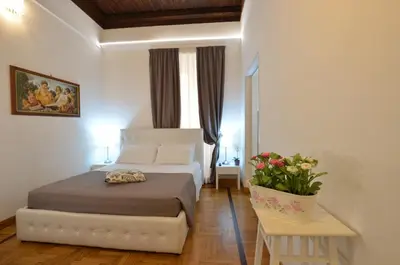 a bedroom with a bed and a table with flowers at Roman Nights in Rome
