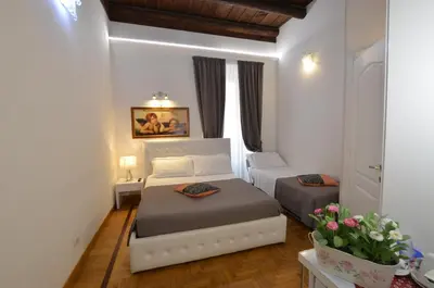 a small bedroom with two beds and a window at Roman Nights in Rome