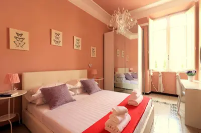a bedroom with a large bed with pink walls and a chandelier at Pamphili Park Romantic Retreat in Rome