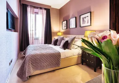 a bedroom with a bed and a large window at The Brunetti - Luxury serviced apartment in Rome