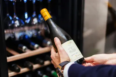 a person holding up a bottle of wine at The Brunetti - Luxury serviced apartment in Rome