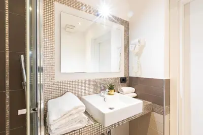 a bathroom with a sink and a mirror at Cesar Vatican Rooms in Rome