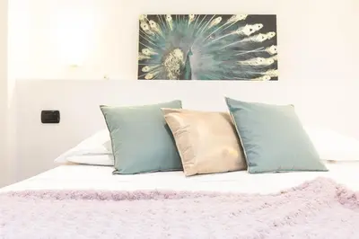a bed with pillows and a painting on the wall at Cesar Vatican Rooms in Rome