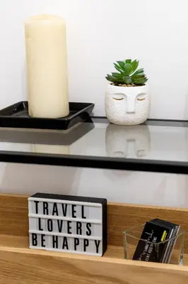 a shelf with a candle and a sign that says have i flowers be happy at Sannio Apartment - near Metro San Giovanni by RHR in Rome