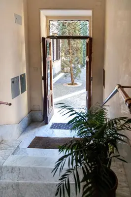 an open door to a hallway with a potted plant at Sannio Apartment - near Metro San Giovanni by RHR in Rome