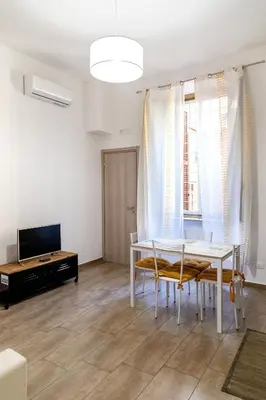 a living room with a table and chairs and a tv at Sannio Apartment - near Metro San Giovanni by RHR in Rome