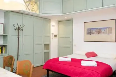 a bedroom with a bed with a red blanket at Coliseum top floor with terrace and view in Rome