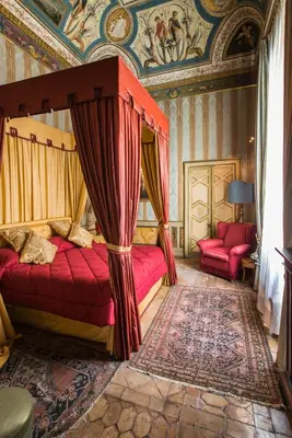 a bedroom with a canopy bed and two red beds at Residenza Ruspoli Bonaparte in Rome