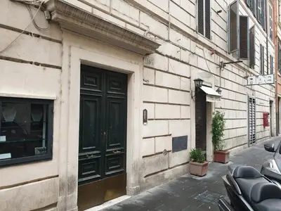 a building with a black door on a street at Centro Storico - Piazza di Spagna in Rome